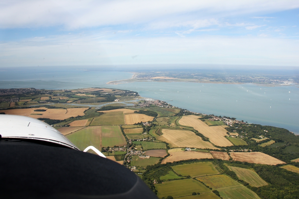 Looking west-north-west from above the Isle of Wight. The river Yar and Yarmouth in the middle distance with Hurst Point and Bournemouth beyond.