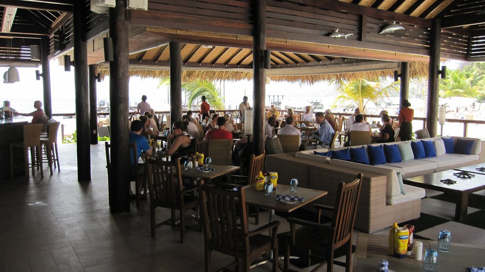 Neptunes restaurant beside the beach, with its bar at the left, and a seating area to the right.