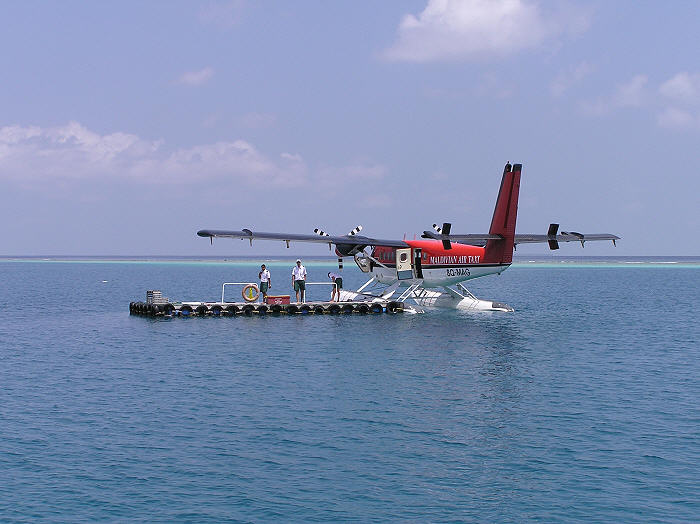 After touching down on the lagoon next to the island, our Twin Otter ties up next to the pontoon. (58k)
