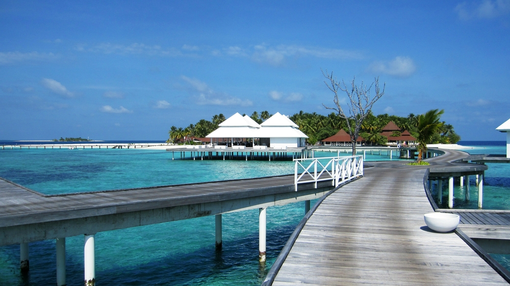 Looking back at the island from the Water Village jetty, with the Water Village restaurant on stilts. The small offshore 
						island, Innafushi, can just be seen beyond the main jetty at the left.