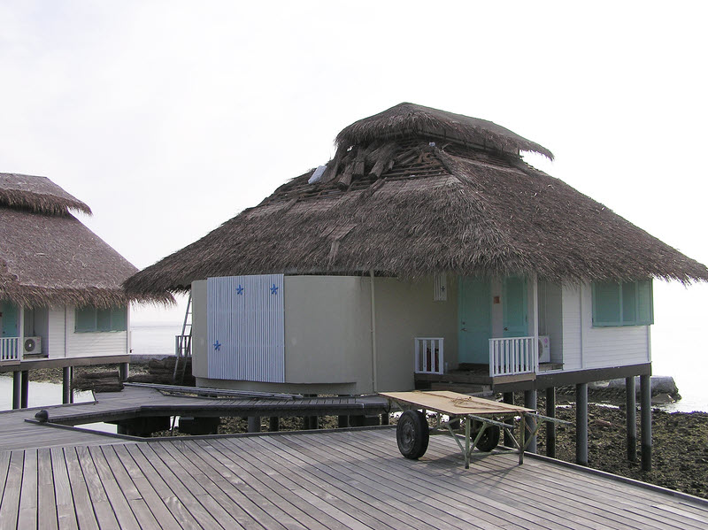 One of the semi-detached water bungalow buildings.�This one was being re-thatched.  (115k)