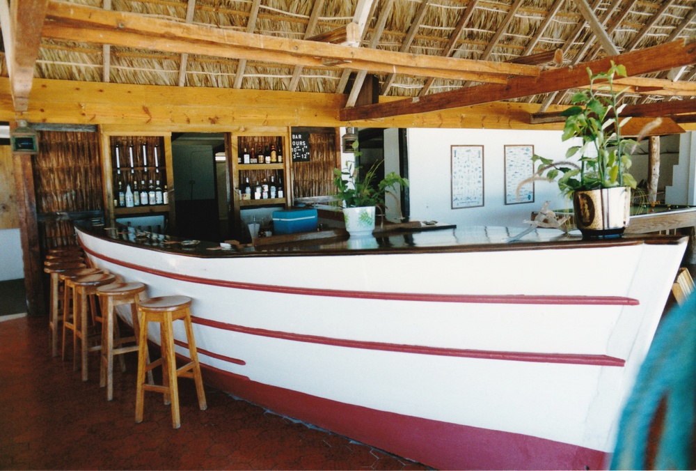 The bar, an old boat dragged up the beach (behind me), and stood in the middle of
            the floor. The barman stands inside the boat, dishing out the drinks.