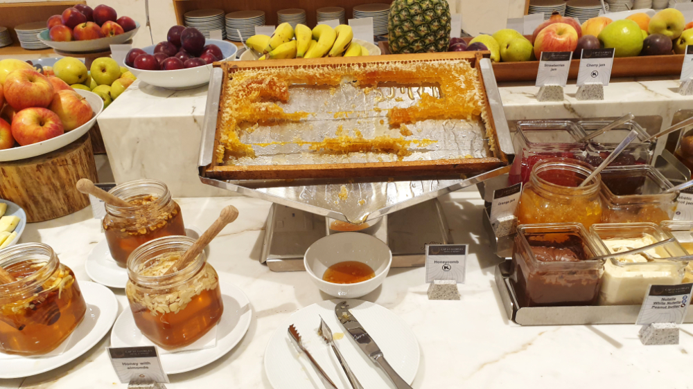 Breakfast choices at Yeronissos restaurant. The honey section includes a frame from a beehive dripping with honey.